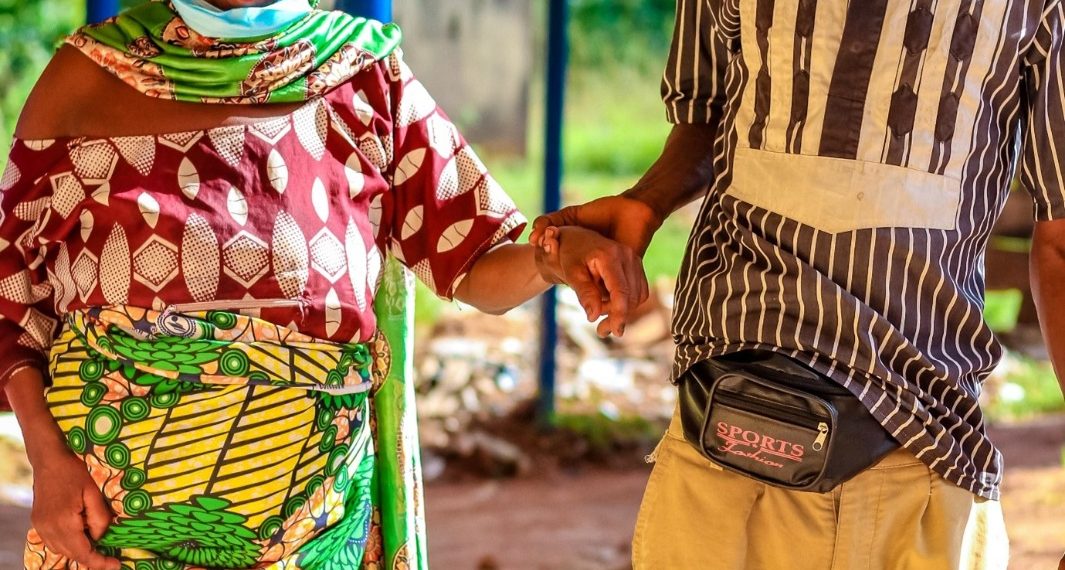 A woman walking in an hospital environment and a young man holding her hand