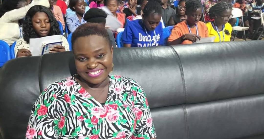 A woman sitting in front with girls at the background