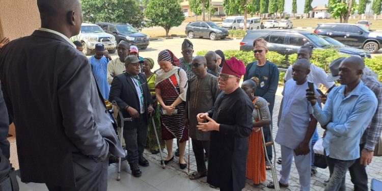 People are facing someone who appears to be the speaker's representatives. The rep is backing the camera and facing the guests