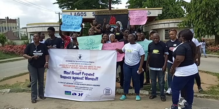 Group of people standing outdoor with a banner and placards