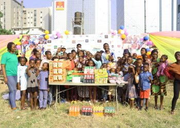 People (including children) standing outdoor. Food items are in front of the people