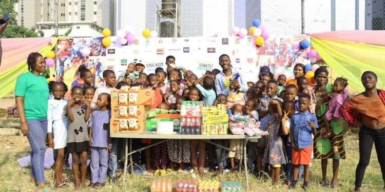 People (including children) standing outdoor. Food items are in front of the people