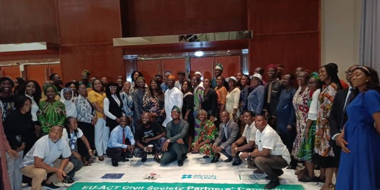 People in a group picture. The banner with EU-ACT is placed on the bare floor