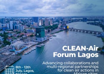 Aerial view of a city with tall buildings, a body of water passing through with a bridge