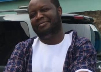 A man standing outdoor, hands folded