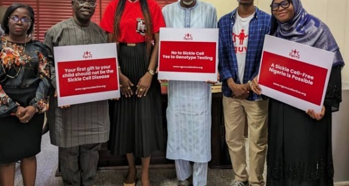 Six people are standing indoor. three of them are holding placards in their hands