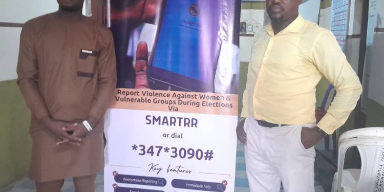 Two men standing indoor in front of a roll up banner