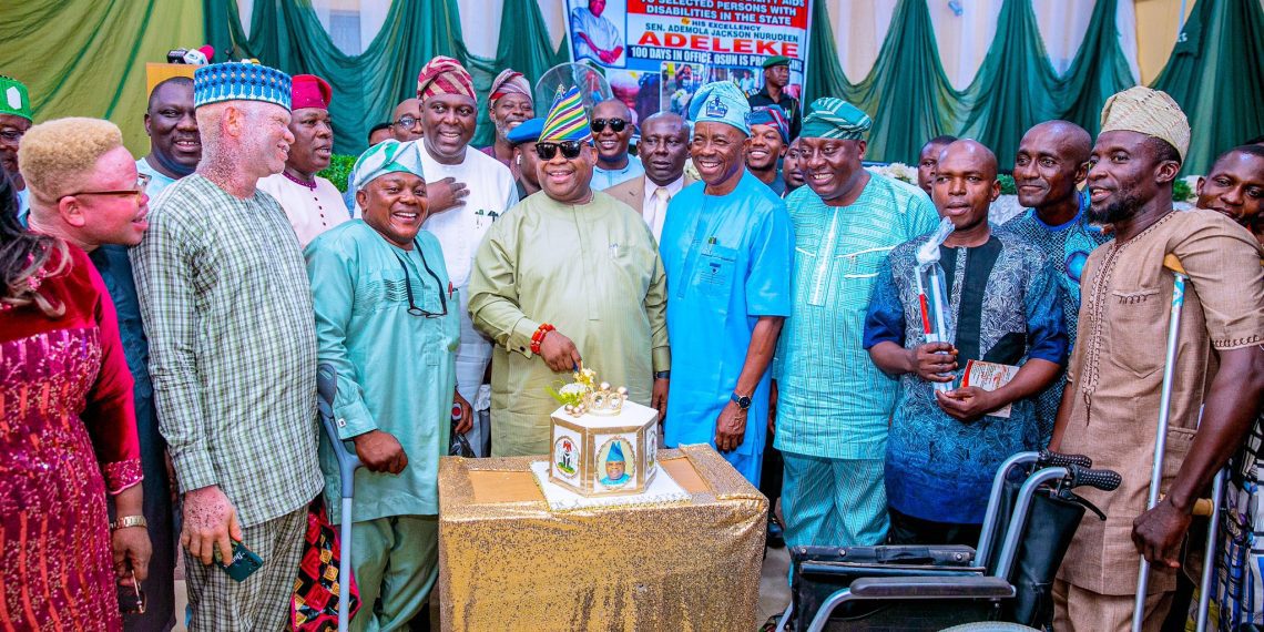 An image of the governor with people with disabilities , they were cutting cake