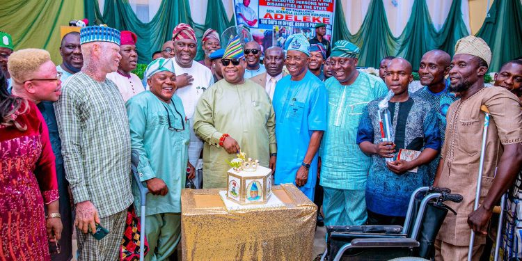 An image of the governor with people with disabilities , they were cutting cake