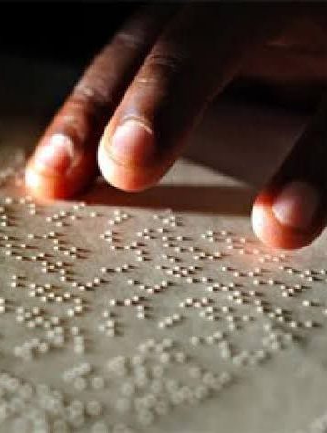 The image of someone's hand trying to read braille