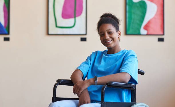 Colorful portrait of black teenage girl with disability smiling at camera while visiting modern art gallery or museum, copy space
