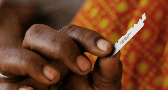 A hand holding half a blade of razor