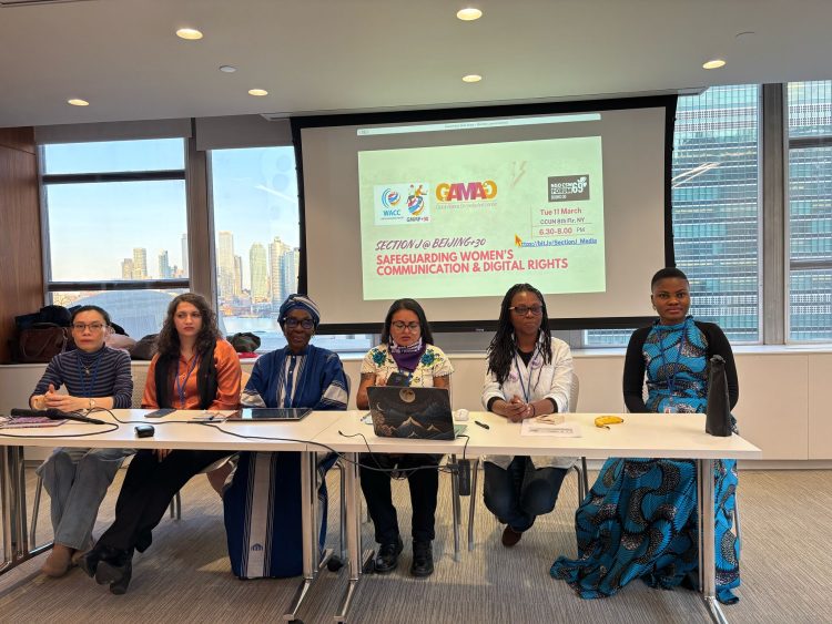 six women indoor sitting in front of a table with a computer on the table