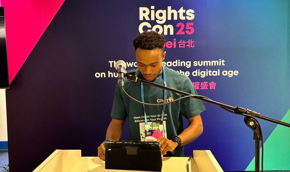 A man standing indoor in front of a podium