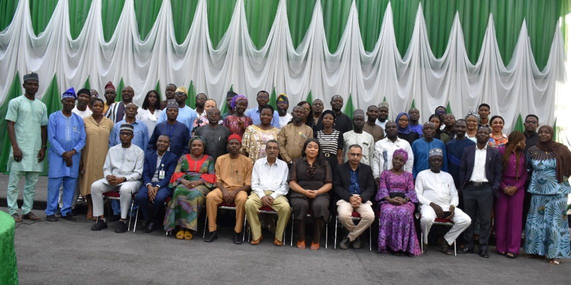 A group of people indoor. Some are standing and some are sitting