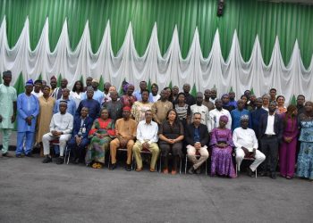 A group of people indoor. Some are standing and some are sitting