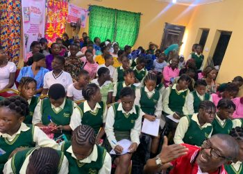 A groupoup of girls wearing uniform seated indoor