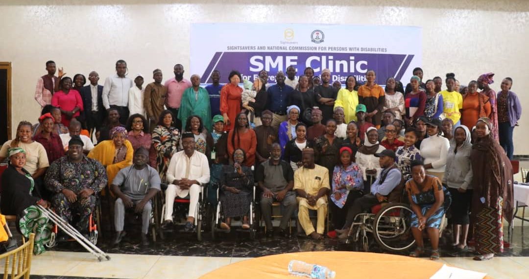 Group of people indoor. Some standing, seated and others on wheelchair