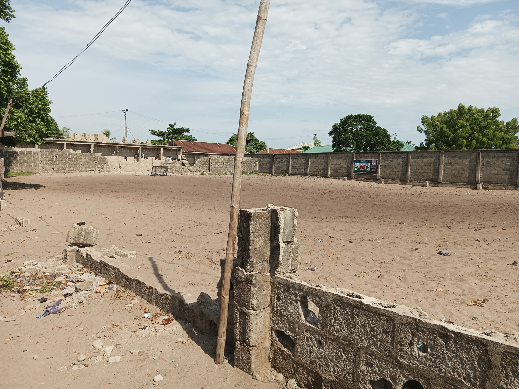 A fenced dry land. Part of the fence is broker