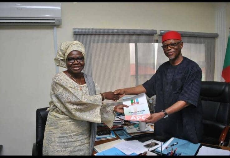 A man and a woman in standing position indoor exchanging a paper document