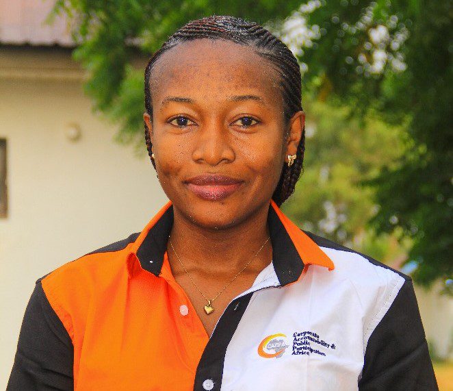 The headshot of a woman. She wears a customised tshirt with orange, whhite and black clours. On her shirt is the logoo of CAPPA.