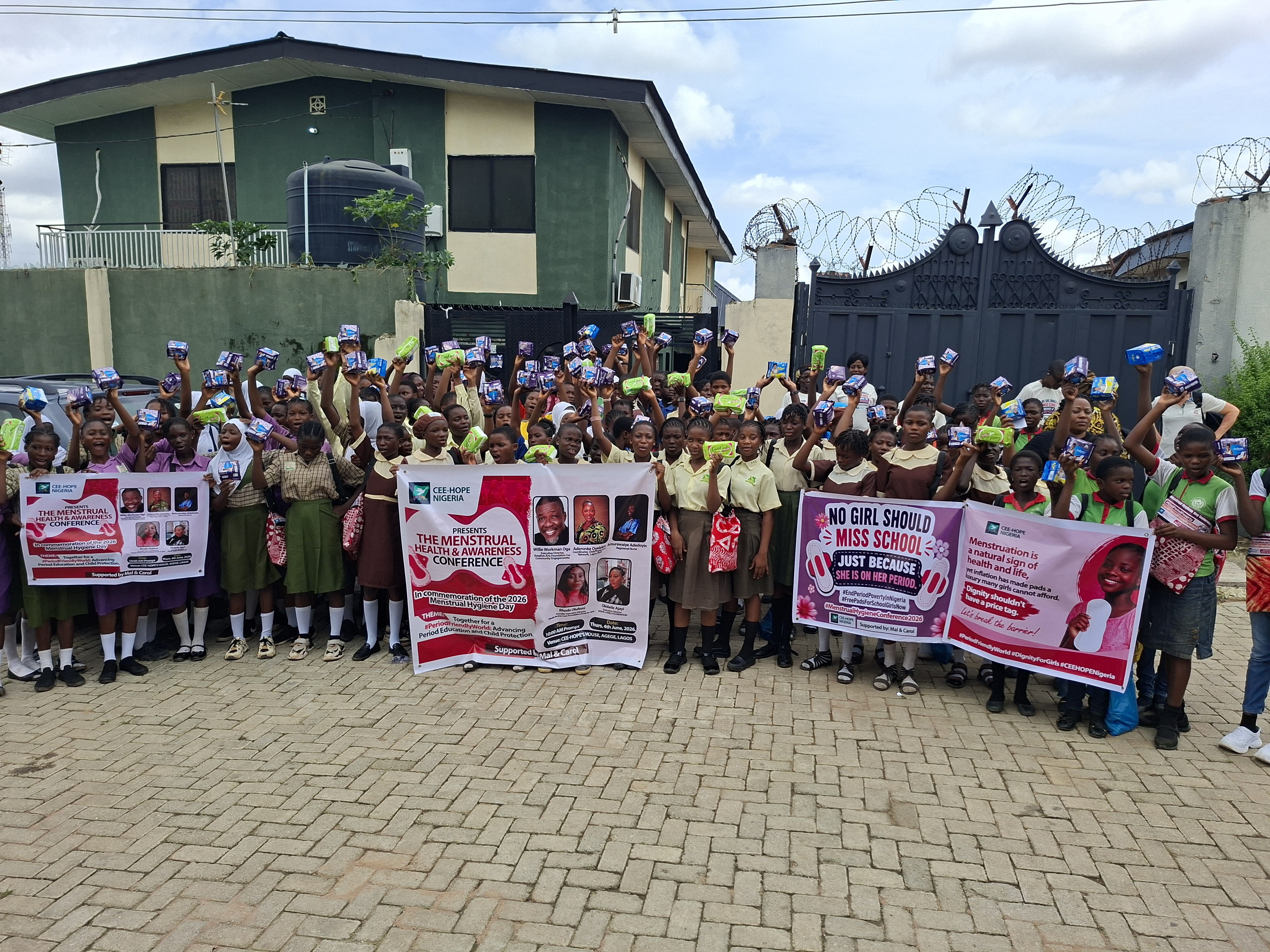 Schoolgirls at CEE-HOPE's Menstrual Health and Awareness Conference, holding sanitary pads distributed to them. February 4, 2026.