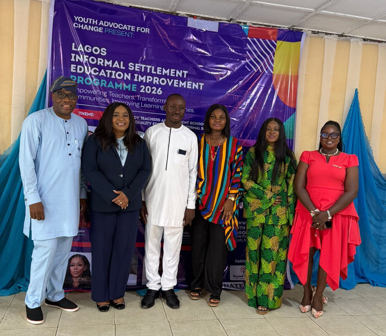 Educatiion stakeholders standing in a group photo behind a banner.