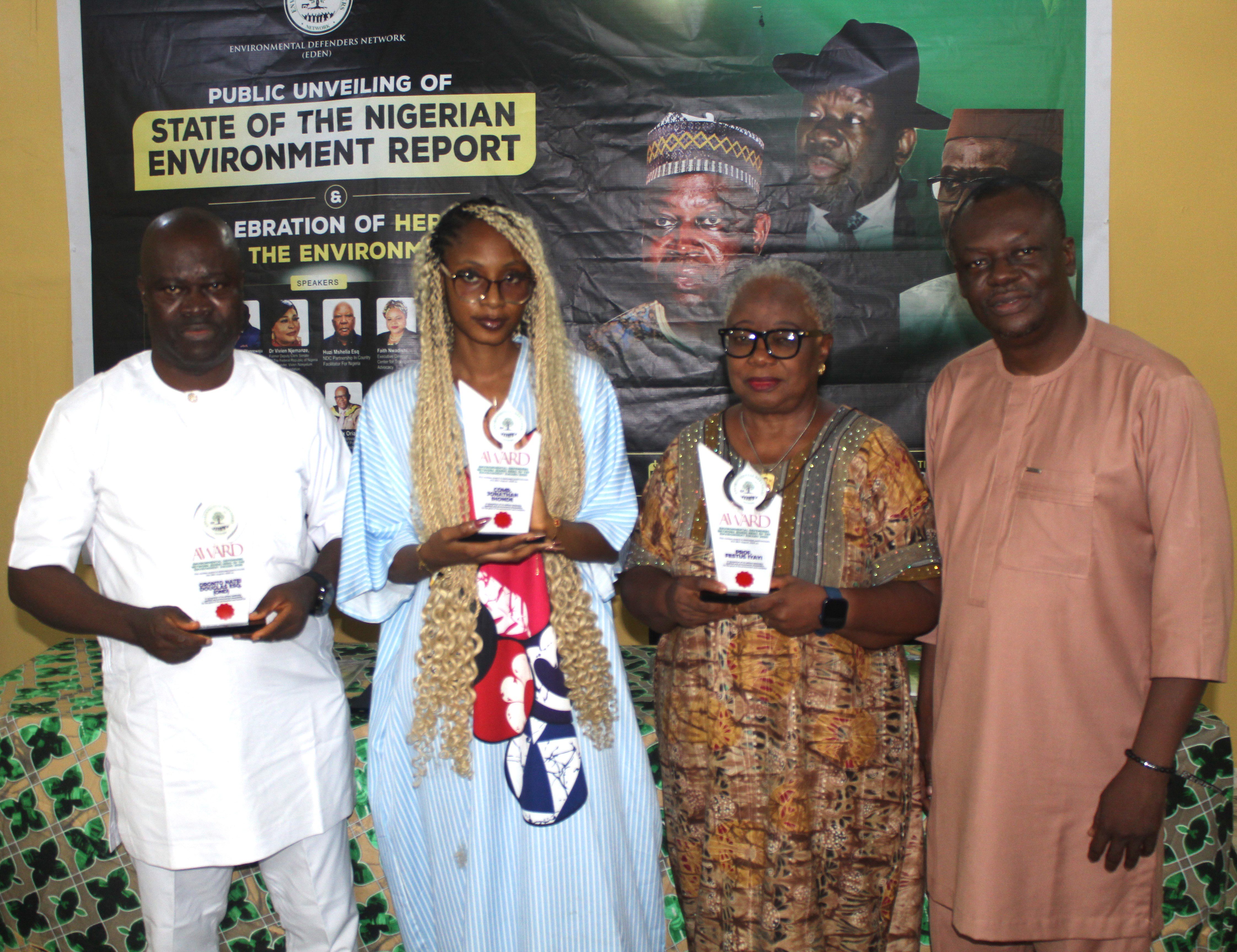 A group photo of four people; two men and two women. The women are holding awards presented by EDEN.